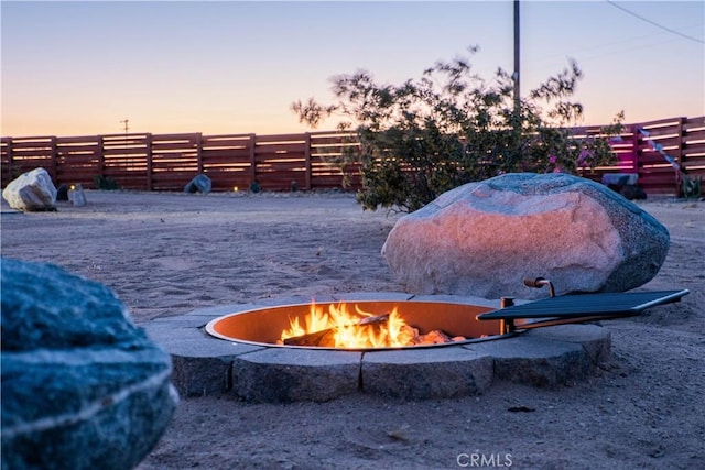 yard at dusk featuring a fire pit