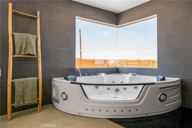 interior space featuring a tub to relax in, a healthy amount of sunlight, and tile walls