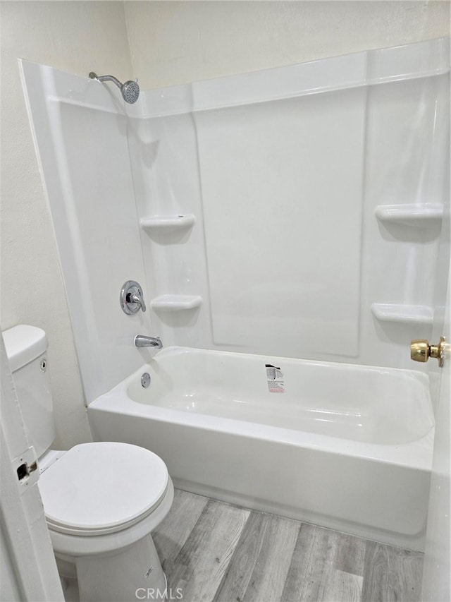 bathroom with toilet, wood-type flooring, and shower / bathtub combination