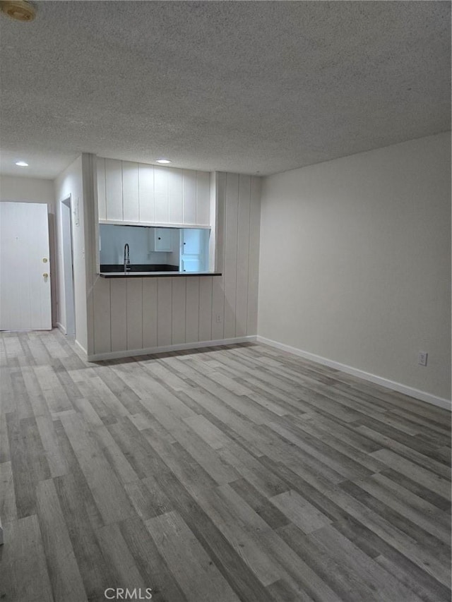 1030 W Macarthur Blvd Unit 83, Santa Ana, CA 92707 - unfurnished living room with wood finished floors, a textured ceiling, and recessed lighting