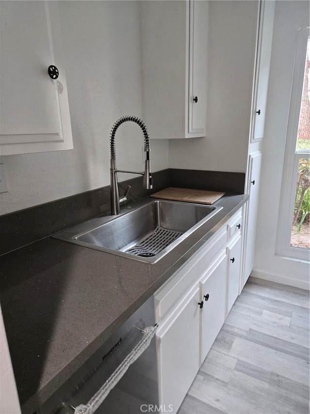 1030 W Macarthur Blvd Unit 83, Santa Ana, CA 92707 - kitchen with dark countertops, white cabinetry, light wood-type flooring, and dishwasher
