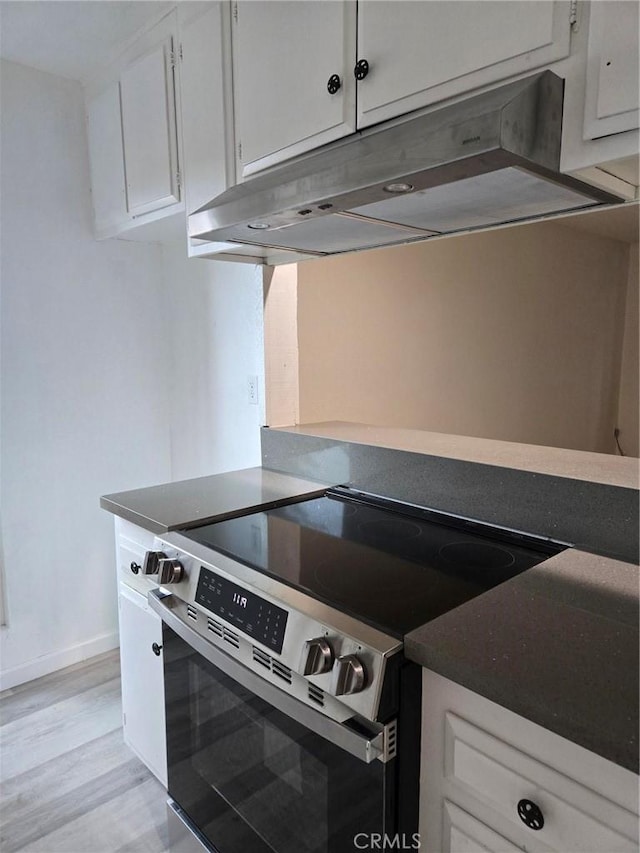 1030 W Macarthur Blvd Unit 83, Santa Ana, CA 92707 - kitchen featuring electric stove, under cabinet range hood, white cabinetry, and light wood finished floors