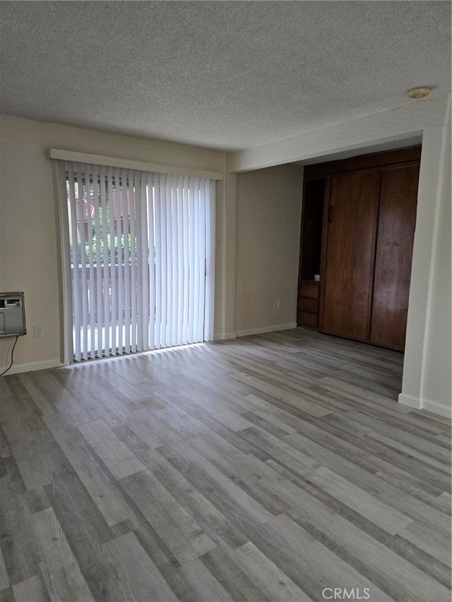 unfurnished living room featuring light hardwood / wood-style floors and a textured ceiling