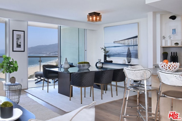 dining area featuring hardwood / wood-style floors and a water view