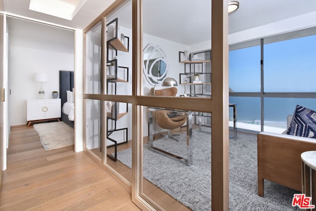 home office with wood-type flooring and floor to ceiling windows