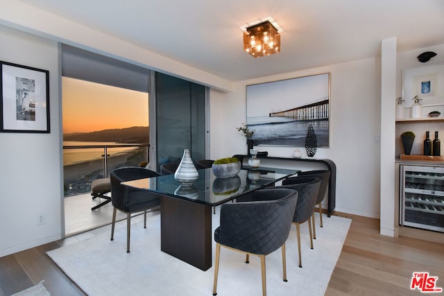 dining space with hardwood / wood-style flooring and beverage cooler