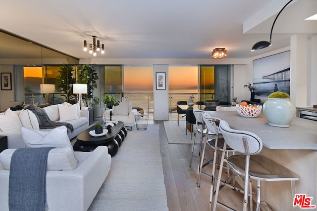 living room featuring a notable chandelier and light hardwood / wood-style flooring