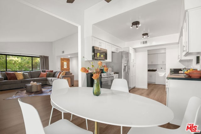 dining room featuring light hardwood / wood-style floors and lofted ceiling