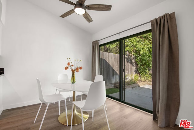 dining area with hardwood / wood-style floors, ceiling fan, and lofted ceiling