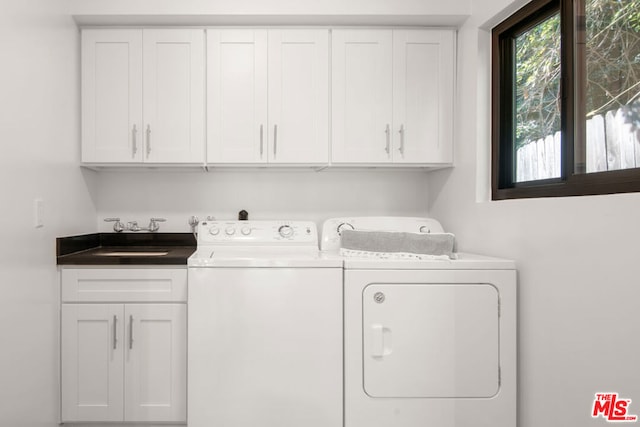 laundry room featuring cabinets, sink, and washing machine and dryer