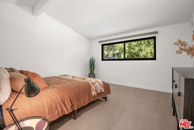 carpeted bedroom featuring vaulted ceiling with beams