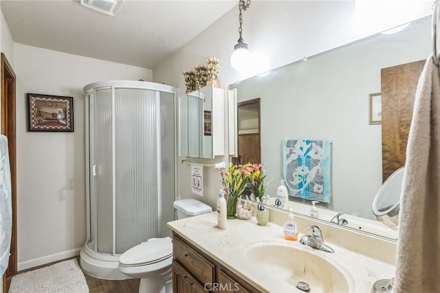 bathroom with vanity, toilet, hardwood / wood-style flooring, and a shower with door