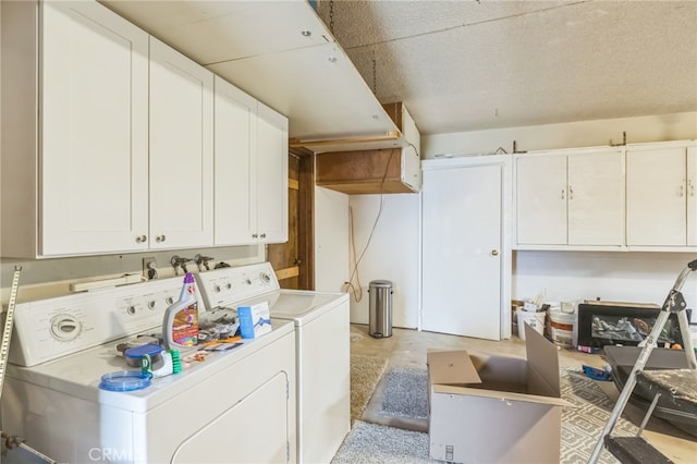 clothes washing area featuring independent washer and dryer and cabinets