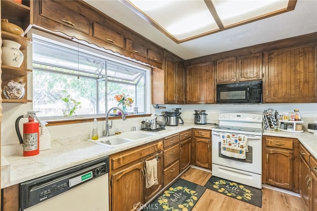 kitchen featuring white appliances, light hardwood / wood-style flooring, and sink