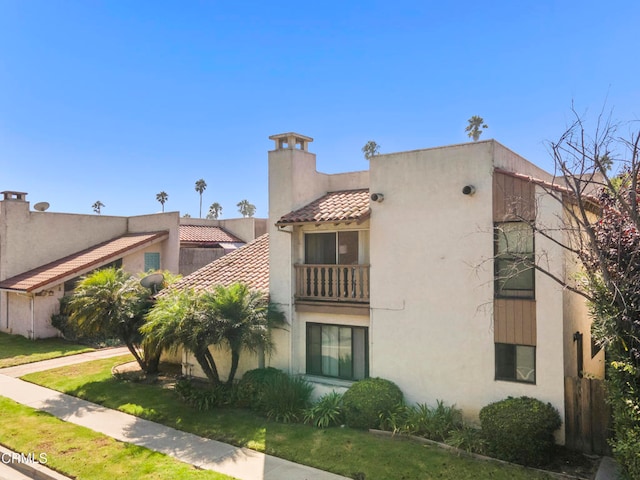 exterior space with a balcony and a front lawn