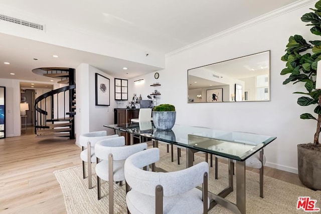 dining room featuring crown molding and light hardwood / wood-style flooring