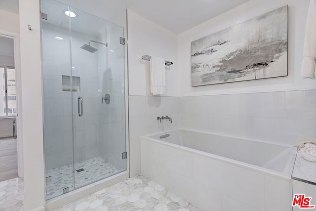 bathroom featuring separate shower and tub