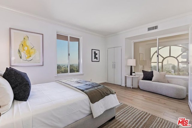 bedroom with light hardwood / wood-style floors and ornamental molding