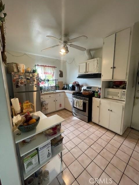 kitchen with light tile patterned floors, stainless steel appliances, and white cabinetry