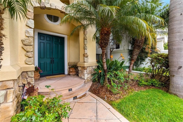 doorway to property featuring stone siding and stucco siding