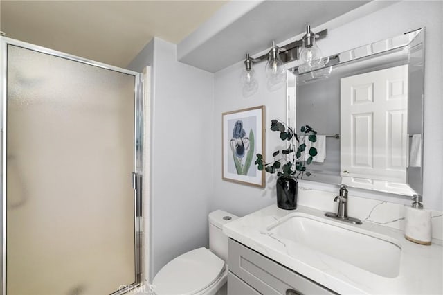 bathroom with a shower stall, toilet, and vanity