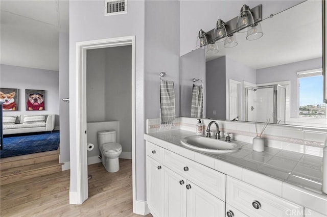 full bathroom with vanity, wood finished floors, visible vents, ensuite bathroom, and toilet