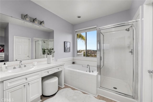 bathroom featuring a garden tub, a stall shower, and vanity