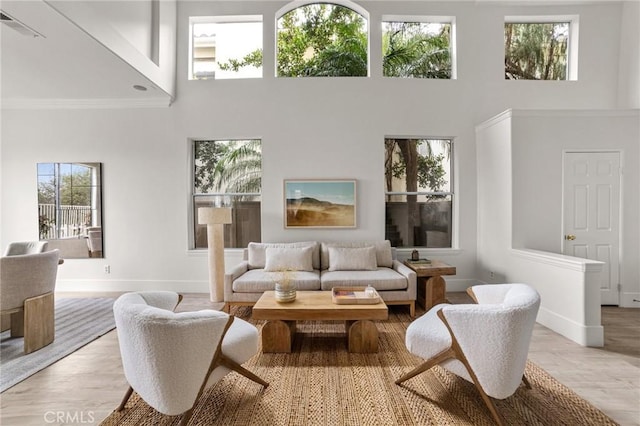 living room featuring visible vents, baseboards, and a high ceiling