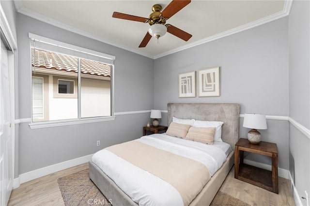 bedroom featuring crown molding, multiple windows, wood finished floors, and baseboards