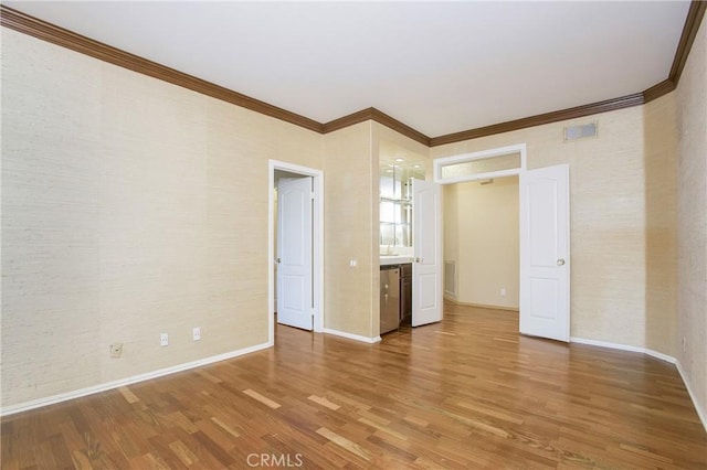 unfurnished bedroom featuring wood-type flooring and crown molding