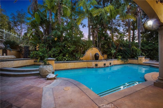 pool at dusk with a patio