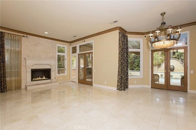 unfurnished living room featuring a chandelier, french doors, and crown molding