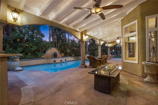 pool at dusk with ceiling fan and a patio