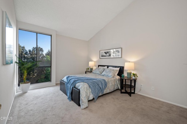 carpeted bedroom with high vaulted ceiling