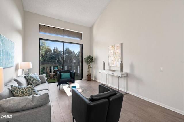 living room with high vaulted ceiling and hardwood / wood-style floors