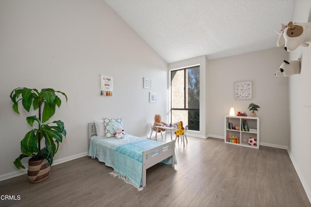 bedroom featuring lofted ceiling, hardwood / wood-style floors, and a textured ceiling