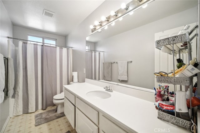 bathroom with vanity, toilet, and walk in shower