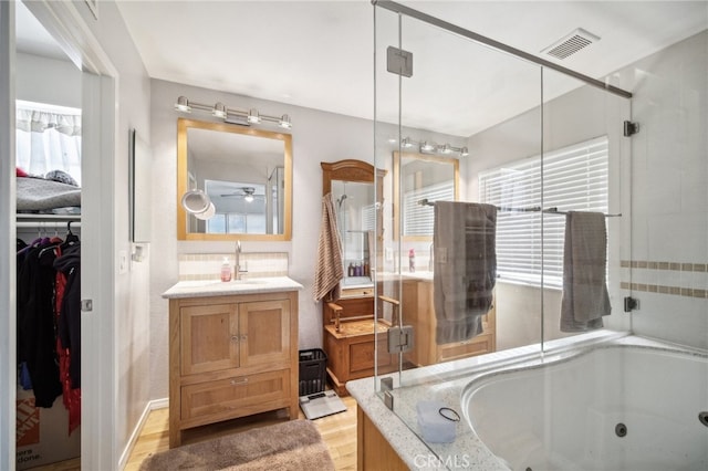 bathroom featuring vanity, separate shower and tub, hardwood / wood-style flooring, and ceiling fan