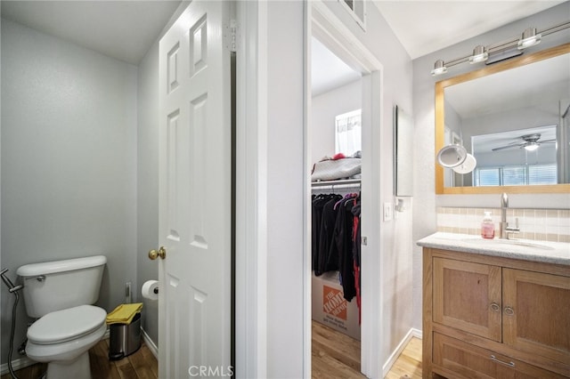 bathroom featuring vanity, hardwood / wood-style flooring, toilet, and ceiling fan