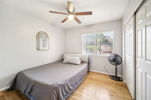 bedroom with a closet, ceiling fan, pool table, and light wood-type flooring