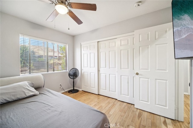 bedroom with a closet, light hardwood / wood-style floors, and ceiling fan