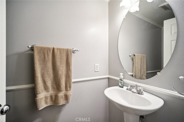 bathroom featuring crown molding and sink