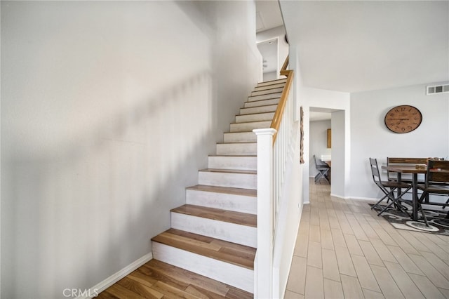 stairs featuring hardwood / wood-style floors