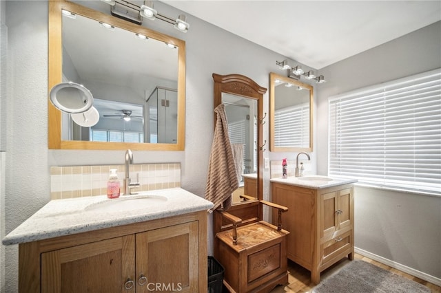 bathroom featuring a shower with door, vanity, decorative backsplash, and ceiling fan