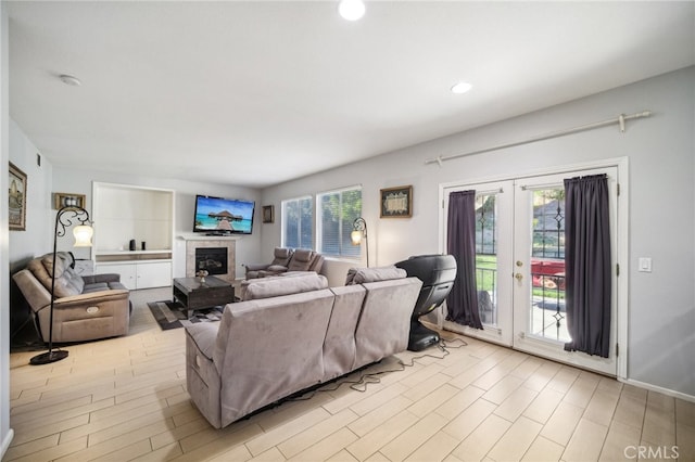 living room with a wealth of natural light, french doors, and light wood-type flooring