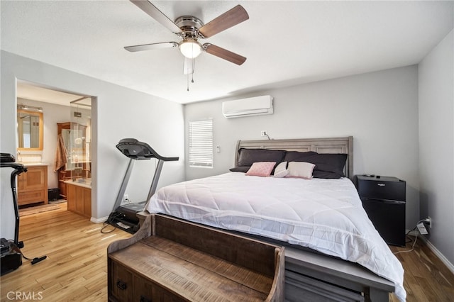 bedroom with light hardwood / wood-style flooring, a wall mounted AC, ensuite bathroom, and ceiling fan