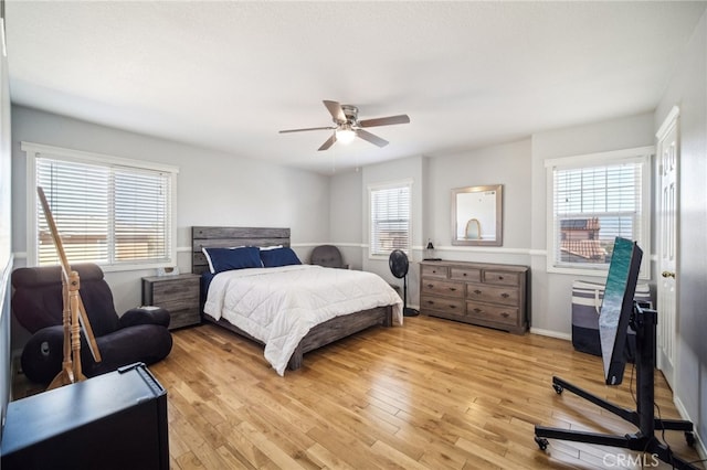 bedroom with light hardwood / wood-style floors, multiple windows, and ceiling fan