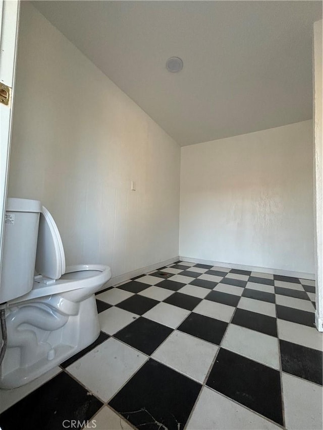 bathroom featuring toilet and vaulted ceiling