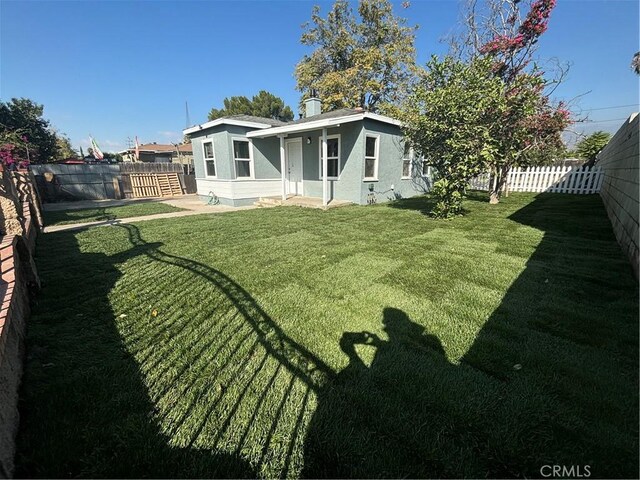 rear view of property with a yard