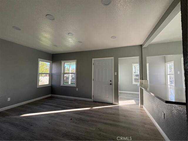 entrance foyer featuring a textured ceiling and dark wood-type flooring